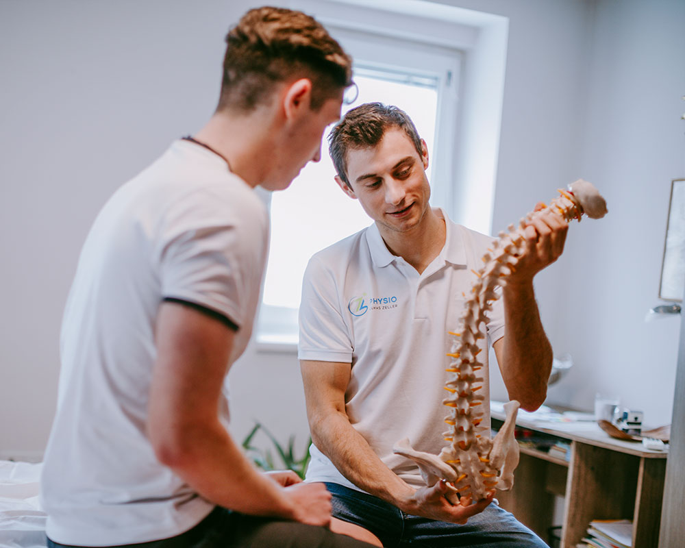 Physiotherapeut Lukas Zeller erklärt einem Patienten die Ursache seiner Beschwerden.